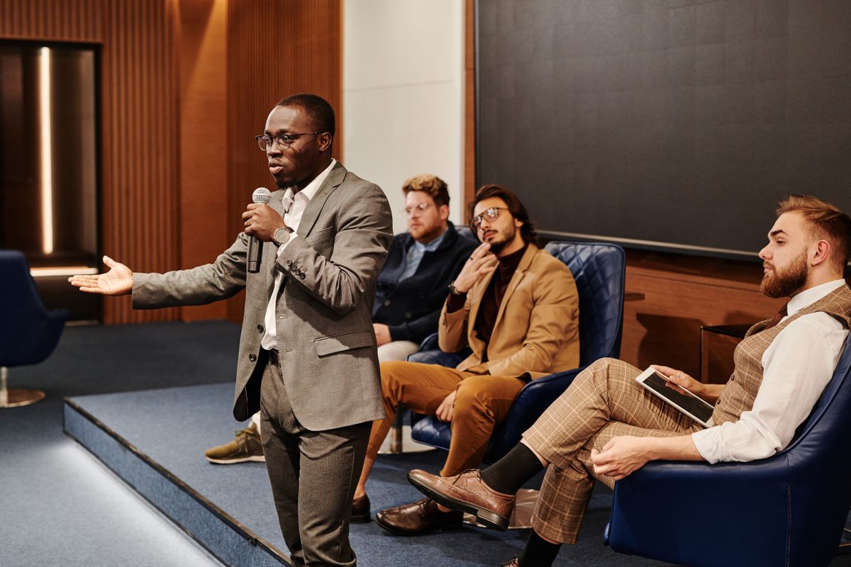A speaker addresses the audience from the stage at a conference